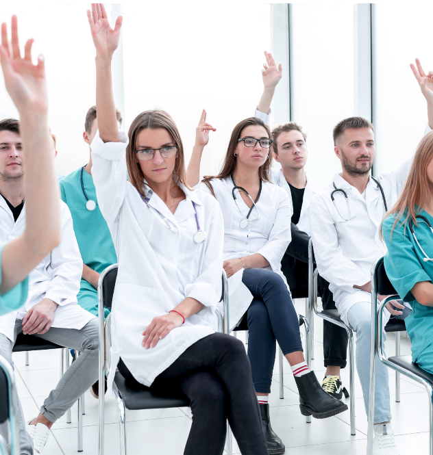a room of lab students raising their hands
